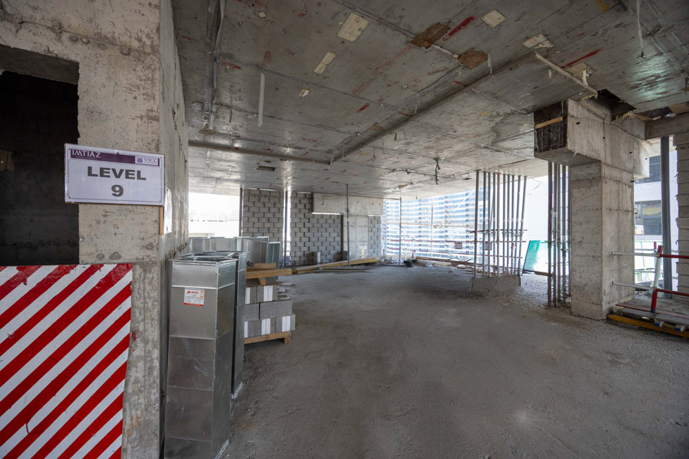 Cove Edition I By Imtiaz 1 Interior of a construction site labeled "Level 9," featuring exposed concrete, scaffolding, and construction materials.